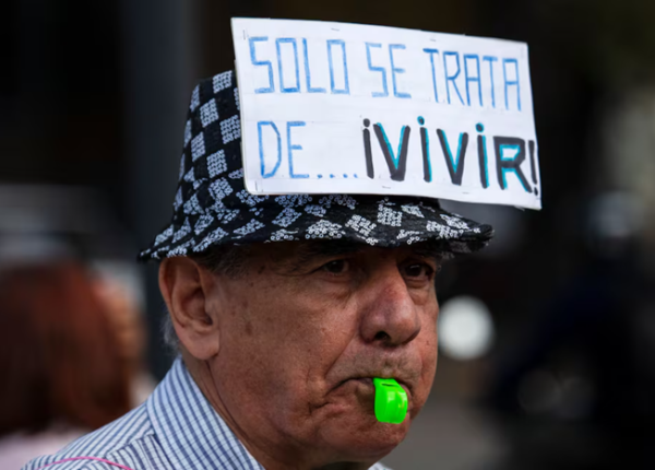 Jubilado con cartel con leyenda "solo se trata de vivir"