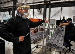 Obrero con barbijo y máscara en fábrica