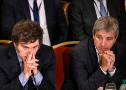 Javier Milei sentado junto a Luis Toto Caputo