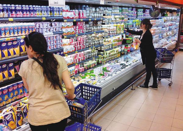 Mujeres comprando yogures en supermercado