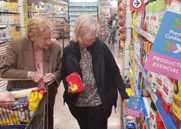 Mujeres en supermercado viendo Precios Esenciales