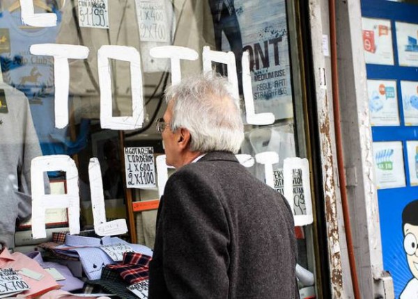 Hombre mirando vidriera con descuentos