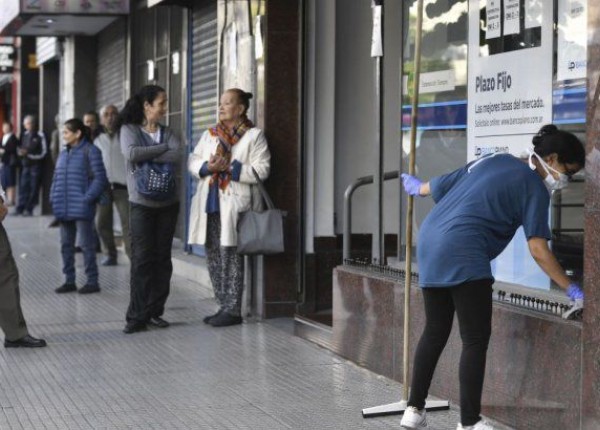 Jubilados haciendo fila delante de un banco