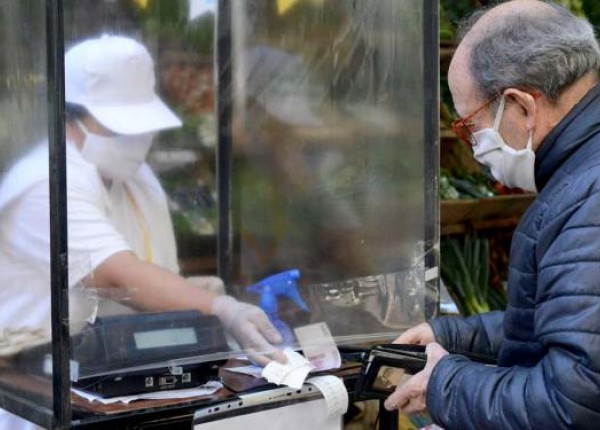 hombre con barbijo comprando en comercio