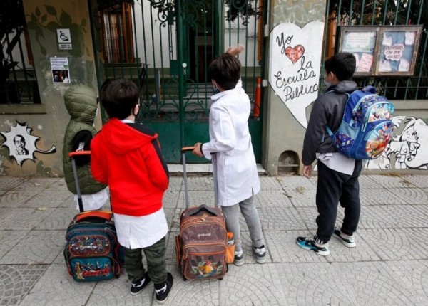 Niños en la puerta de una escuela pública
