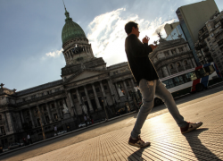 Hombre caminando frente a la fachada del Congreso